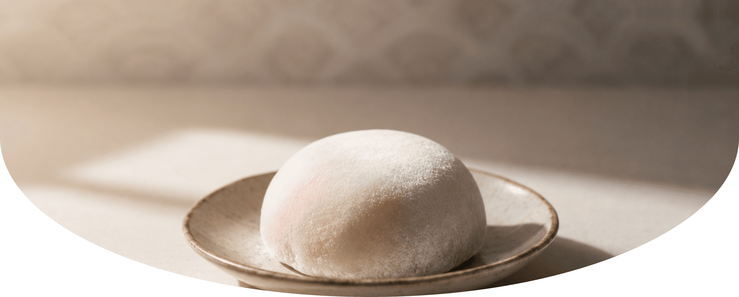 A powdered red bean mochi on a ceramic plate